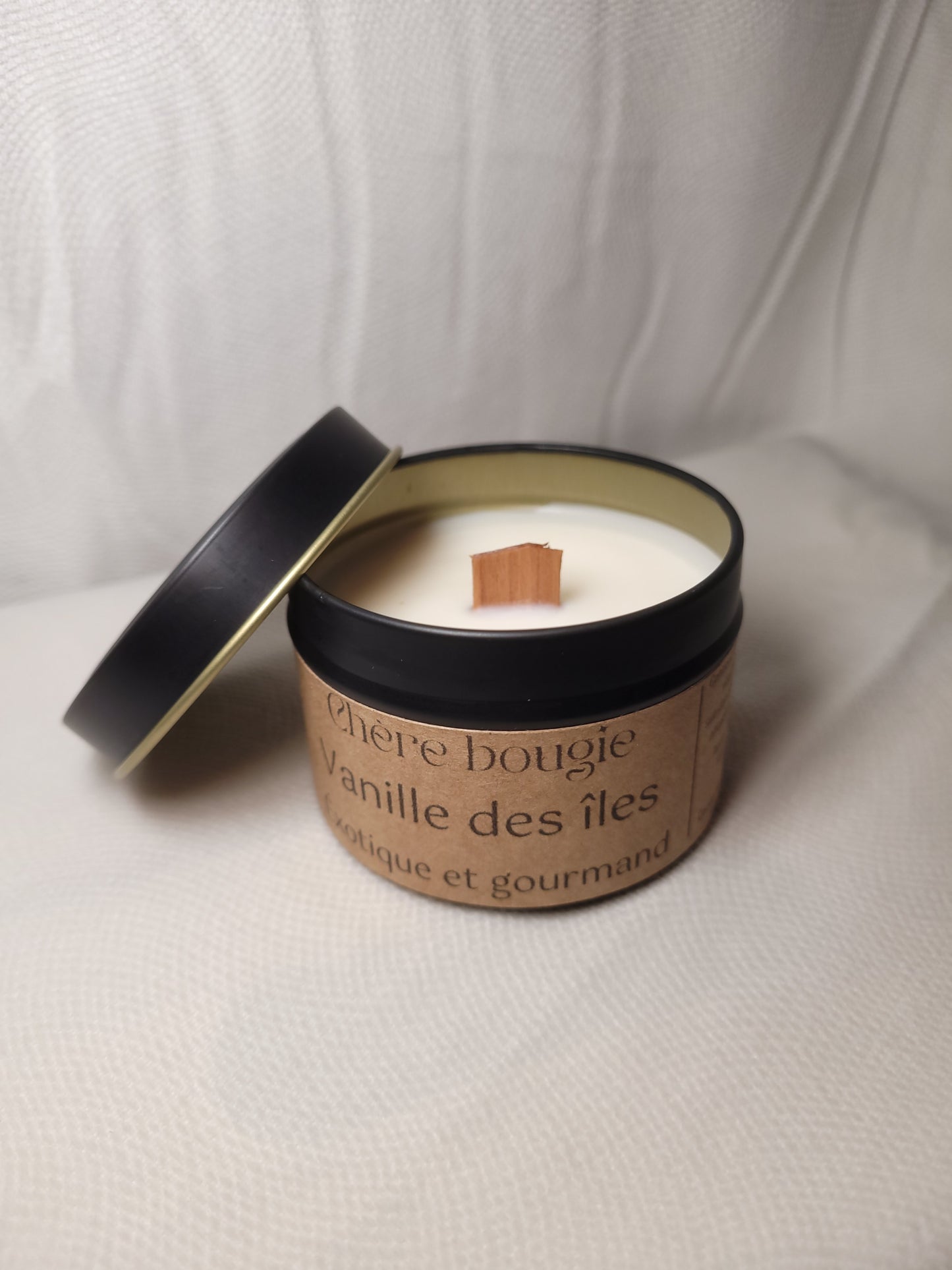 Bougie artisanale à la senteur vanille des îles allumée, créant une ambiance chaleureuse dans une pièce au décor minimaliste.