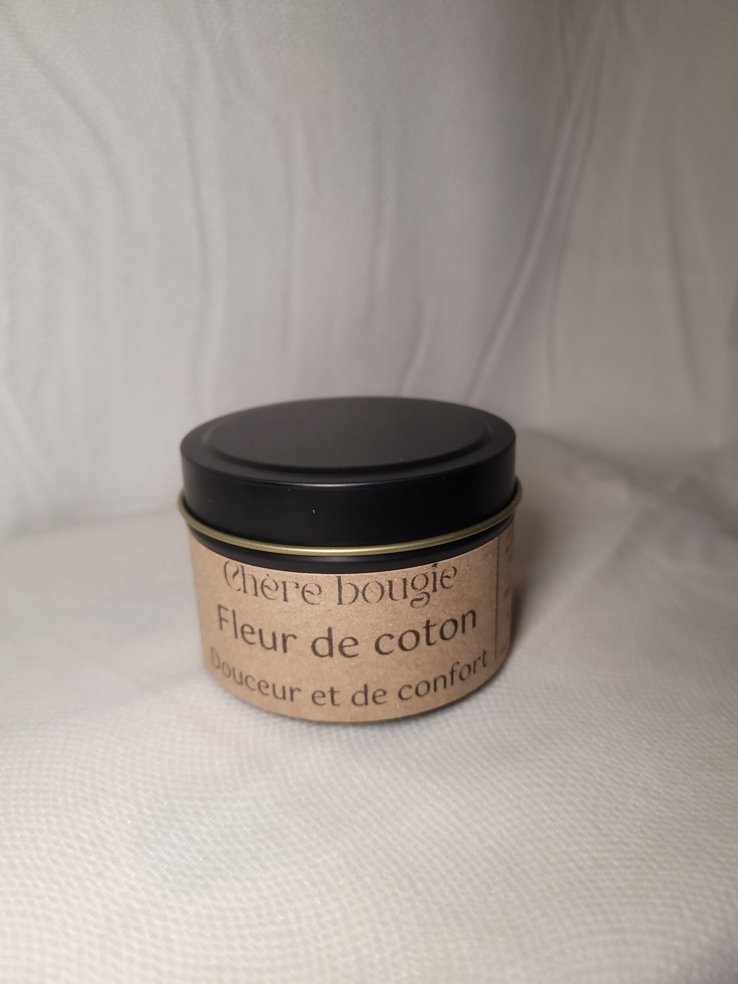 Bougie artisanale Fleur de Coton allumée, diffusant un parfum apaisant et une lumière douce pour une ambiance relaxante.