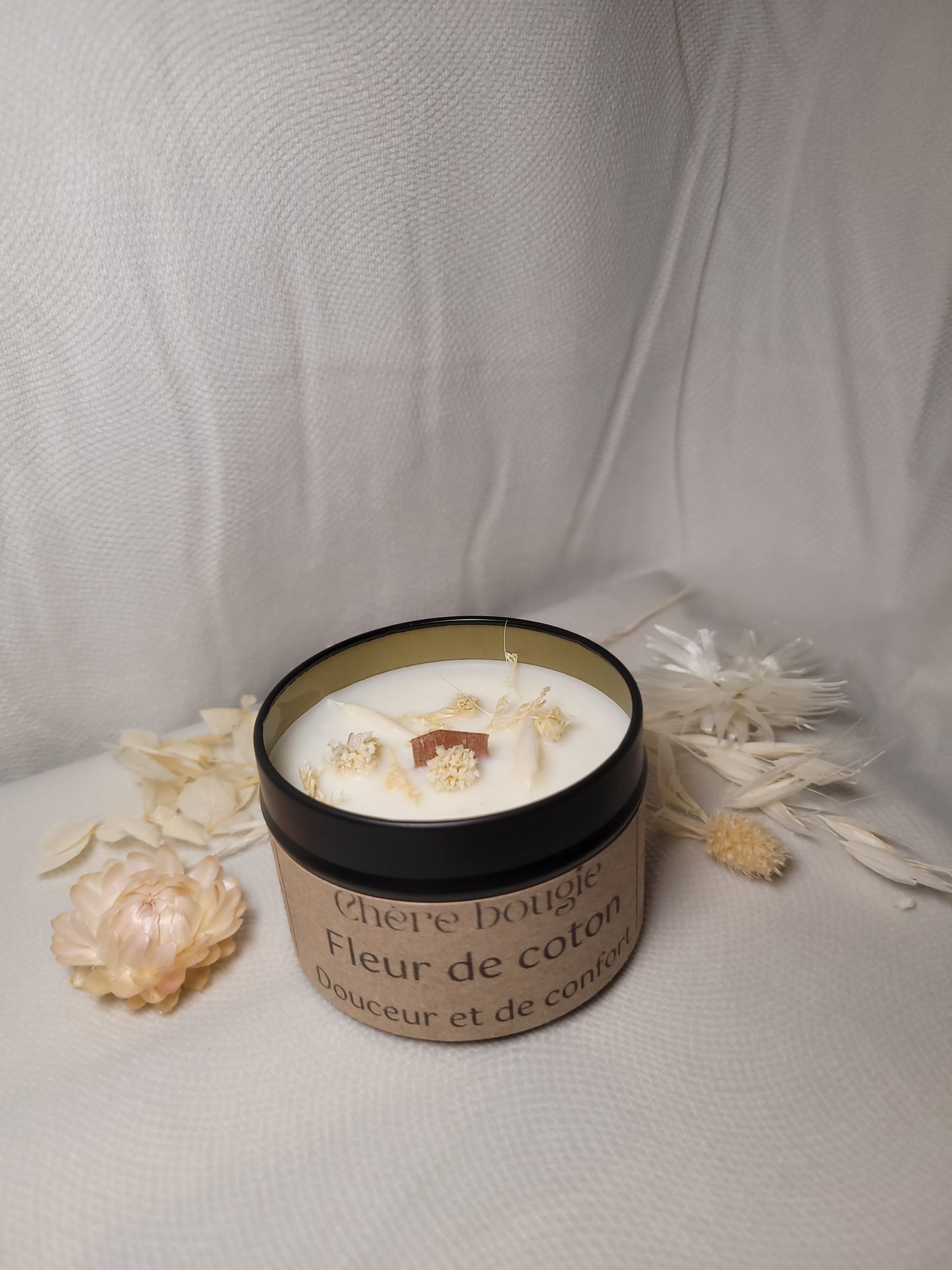 Bougie artisanale Fleur de Coton présentée dans un élégant contenant en métal noir réutilisable.