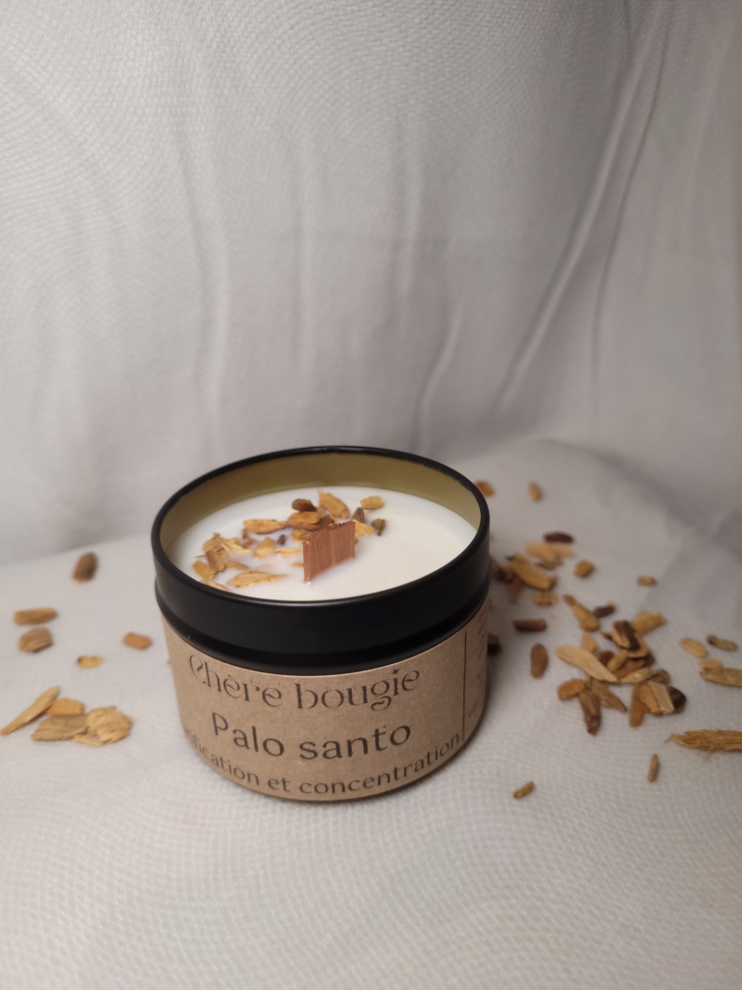 Bougie artisanale à la senteur Palo Santo allumée, diffusant une lumière douce dans un espace apaisant.