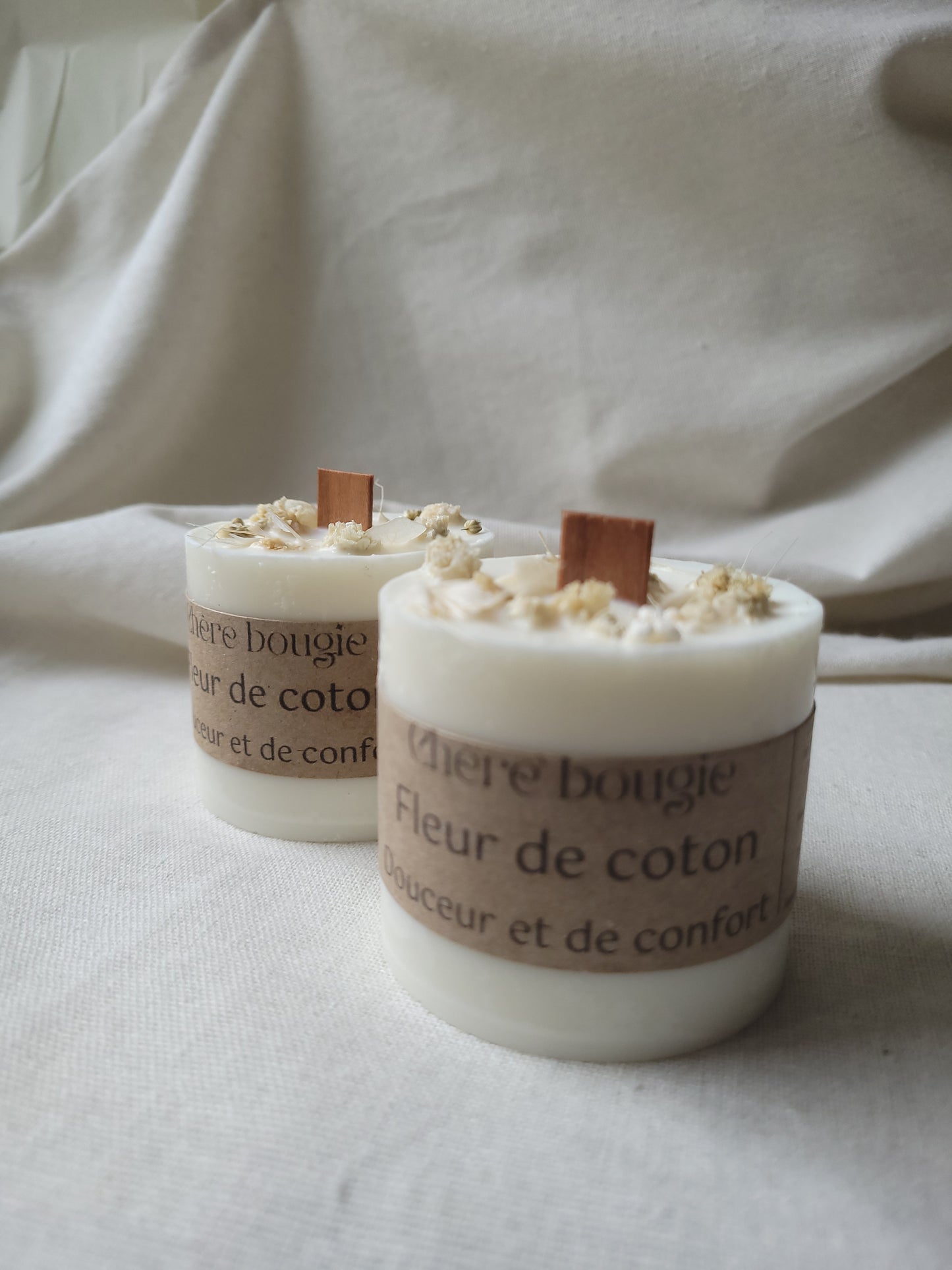 Gros plan sur la mèche en bois de la bougie fleur de coton, mettant en avant la combustion propre et chaleureuse