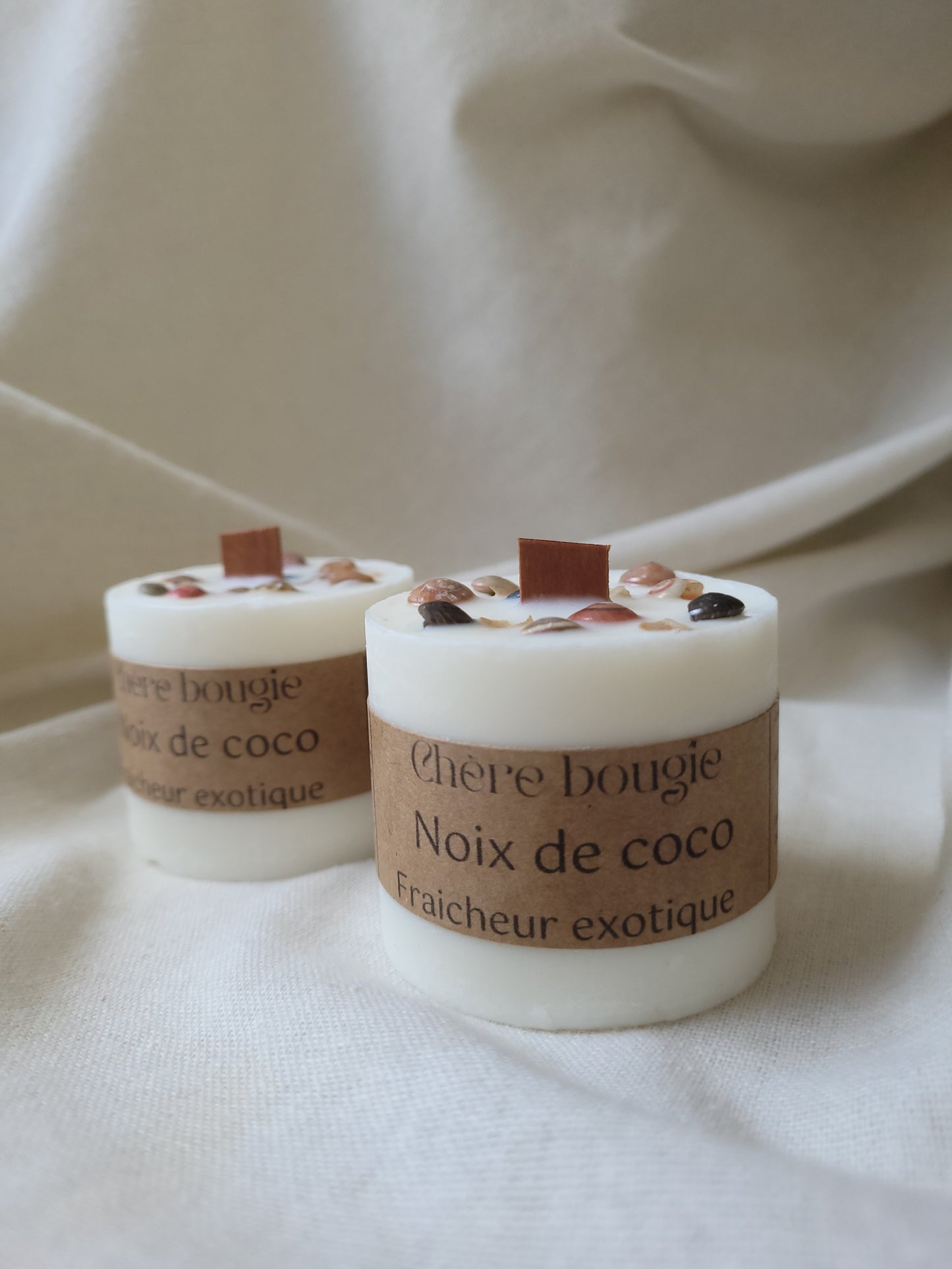 Bougie artisanale à la noix de coco allumée, créant une ambiance tropicale et relaxante dans une pièce.